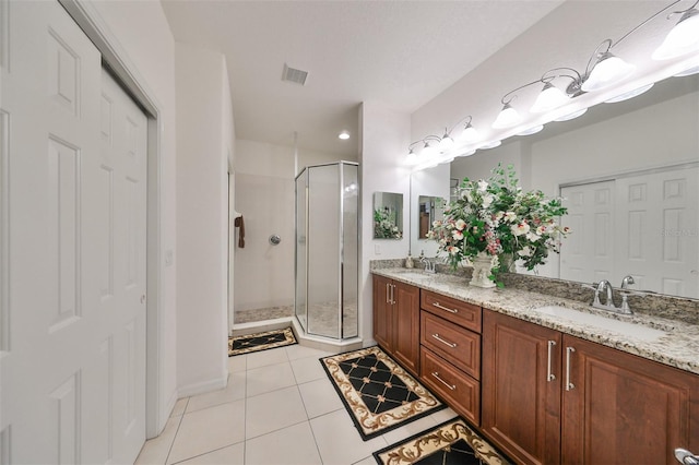 bathroom featuring tile patterned flooring, a shower with shower door, and vanity