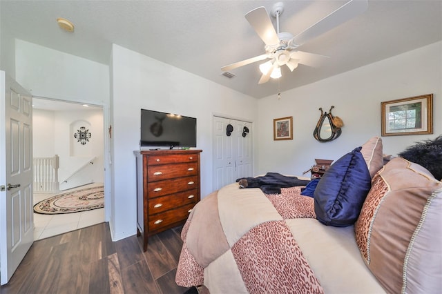 bedroom featuring dark wood-type flooring, ceiling fan, and a closet