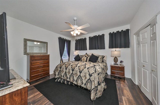 bedroom with a closet, a textured ceiling, ceiling fan, and dark hardwood / wood-style flooring