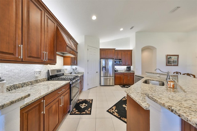 kitchen with stainless steel appliances, sink, light stone counters, lofted ceiling, and light tile patterned flooring