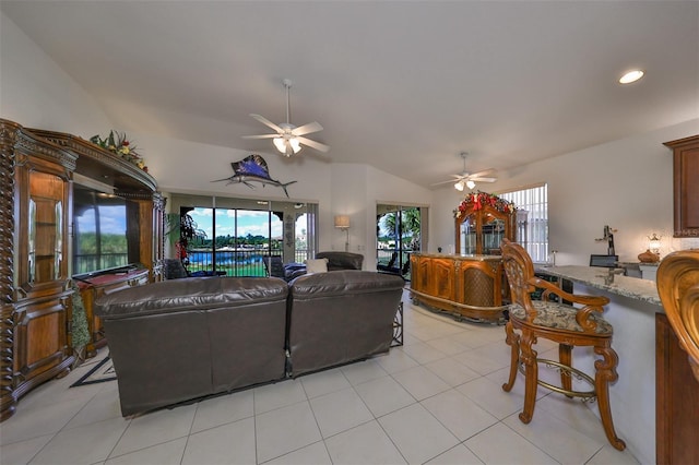 living room with lofted ceiling, ceiling fan, and light tile patterned floors