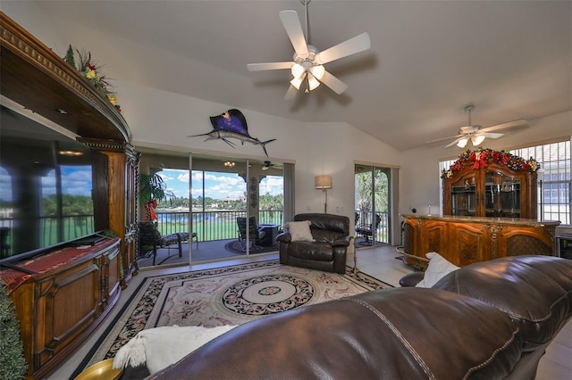 living room featuring lofted ceiling, ceiling fan, a healthy amount of sunlight, and a water view