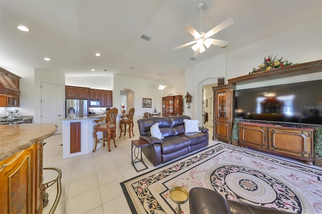 tiled living room featuring ceiling fan and vaulted ceiling