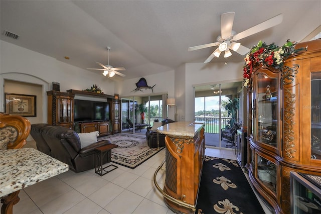 kitchen featuring ceiling fan, light tile patterned flooring, a center island, and lofted ceiling