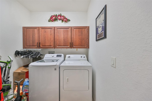 washroom featuring separate washer and dryer and cabinets