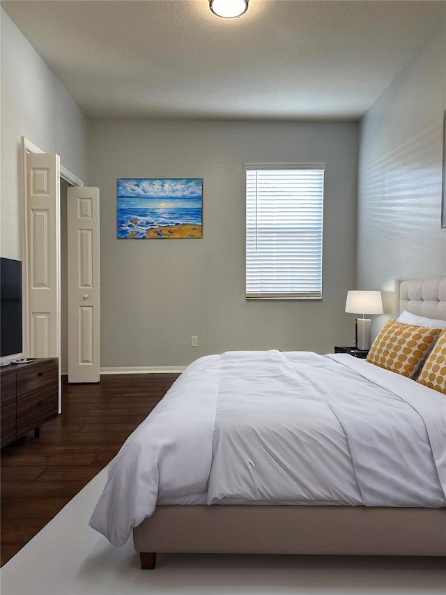 bedroom featuring baseboards and wood finished floors