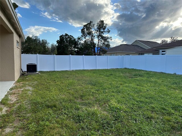 view of yard featuring a fenced backyard and central AC