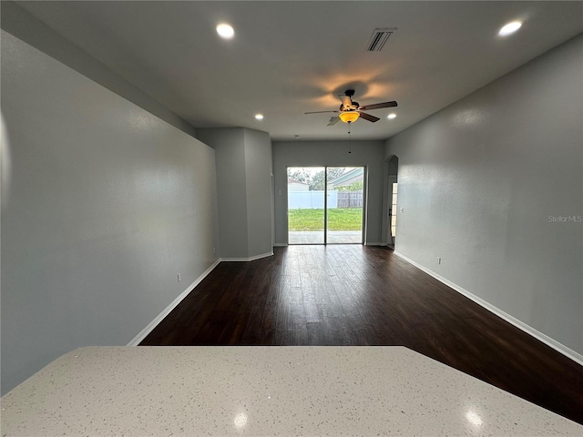 empty room featuring arched walkways, recessed lighting, visible vents, baseboards, and a ceiling fan