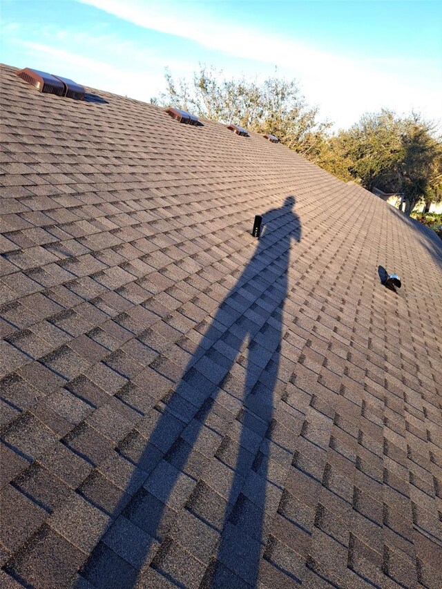 exterior details featuring roof with shingles