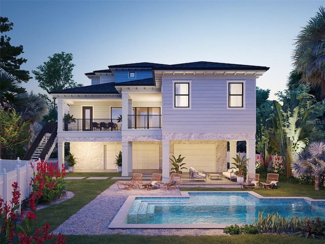 back house at dusk featuring a lawn, a patio, a fenced in pool, and a balcony