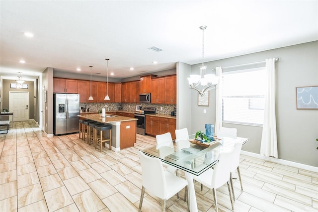 dining space featuring sink and a notable chandelier