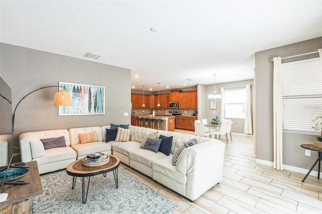 living room featuring a chandelier and light hardwood / wood-style floors