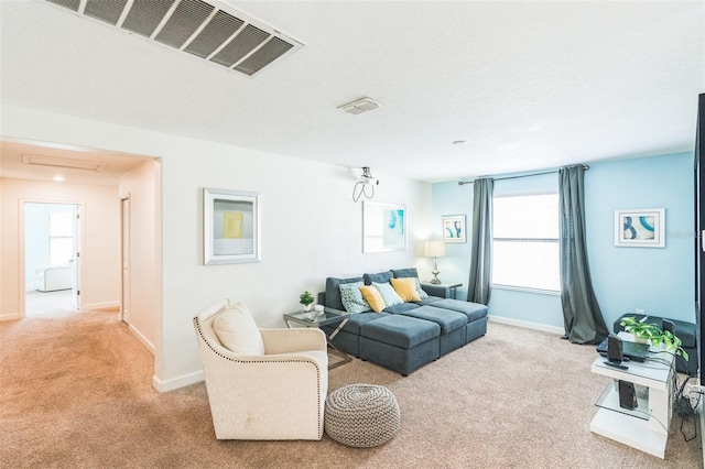 living room with a textured ceiling, light colored carpet, and a wealth of natural light