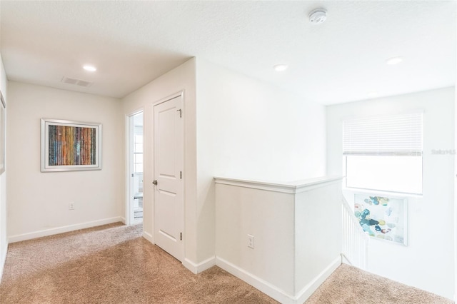 hallway with light colored carpet