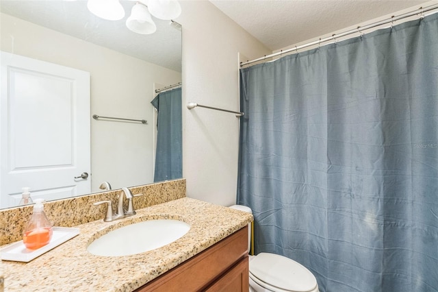 bathroom featuring a textured ceiling, vanity, and toilet