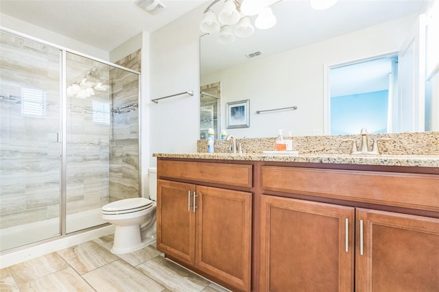 bathroom with vanity, a shower with shower door, and toilet