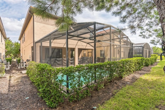 rear view of house featuring glass enclosure