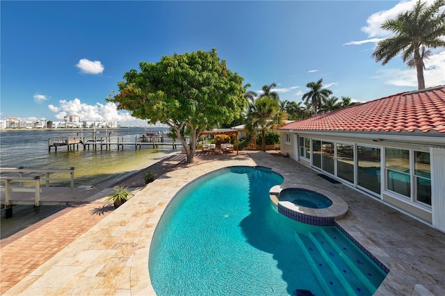 view of pool with an in ground hot tub, a water view, a boat dock, and a patio area