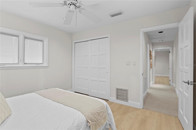 bedroom featuring light hardwood / wood-style floors, ceiling fan, and a closet