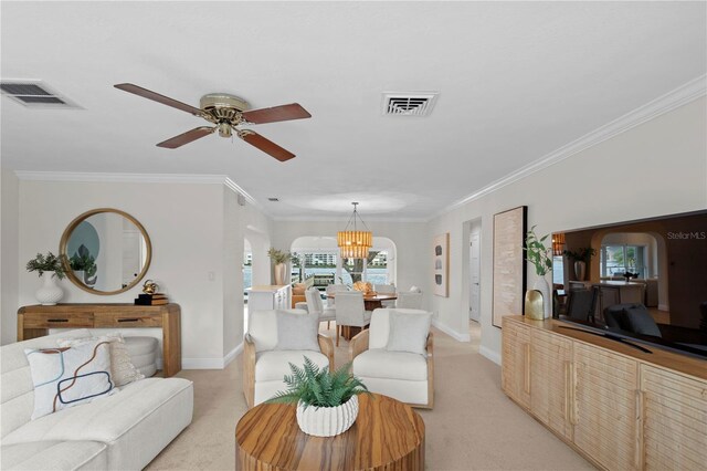 living room featuring ceiling fan with notable chandelier, light colored carpet, and crown molding