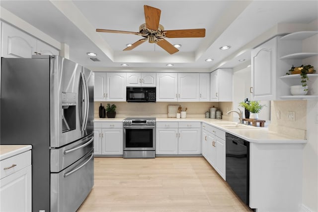 kitchen with black appliances, backsplash, a tray ceiling, and white cabinets