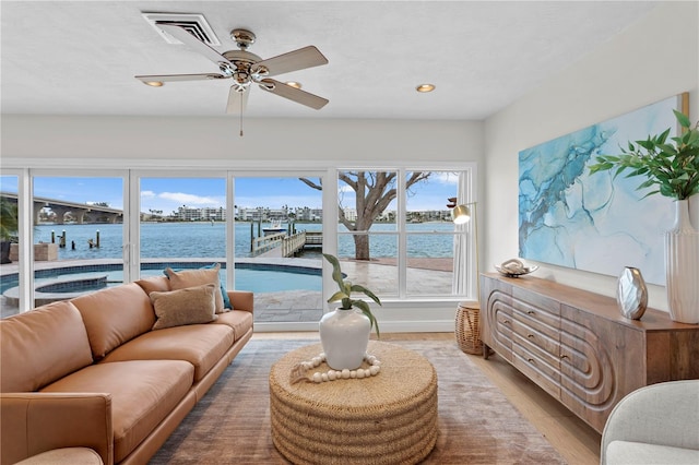 sunroom with a water view and ceiling fan