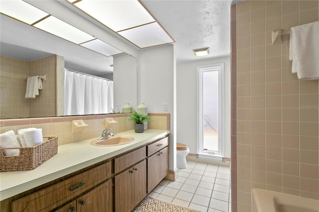 bathroom featuring tasteful backsplash, tile walls, tile patterned floors, vanity, and toilet