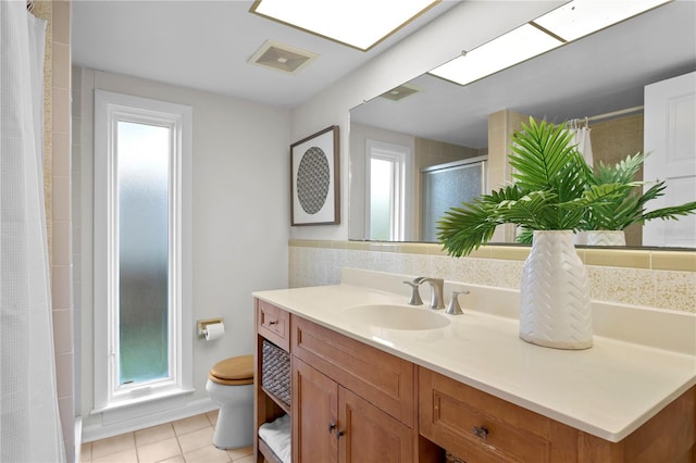 bathroom featuring toilet, a wealth of natural light, and tile patterned flooring