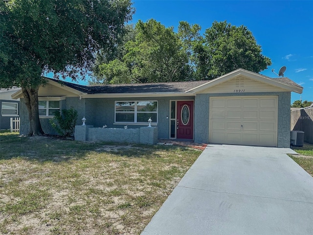 single story home with a garage, central AC, and a front yard