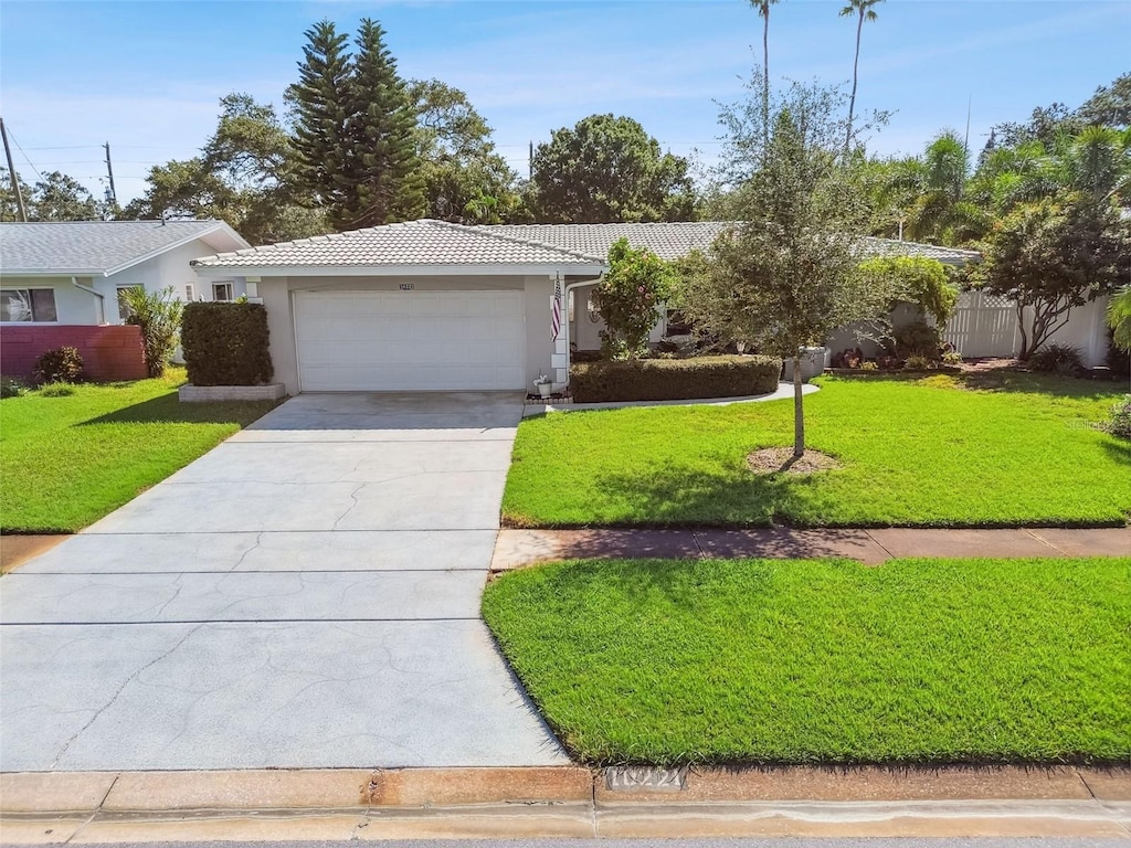 single story home featuring a front lawn and a garage