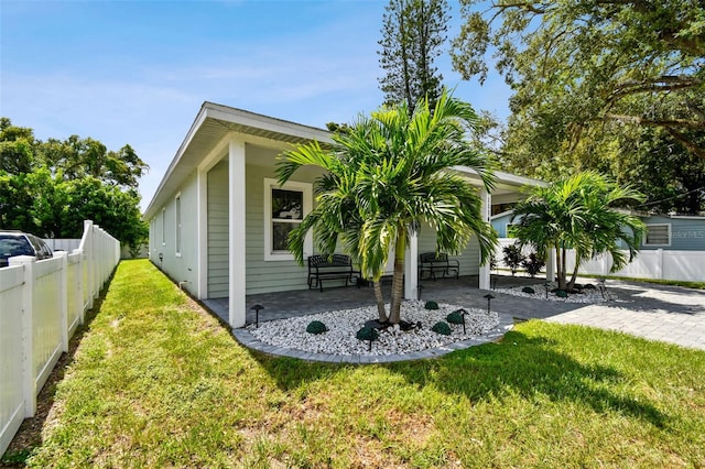 view of side of home with a patio and a yard