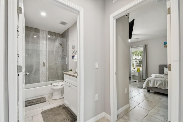 full bathroom with bath / shower combo with glass door, vanity, tile patterned flooring, and toilet