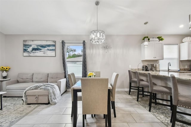 tiled dining space with a chandelier and sink