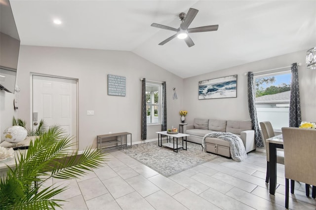 living room featuring ceiling fan, light tile patterned floors, and vaulted ceiling