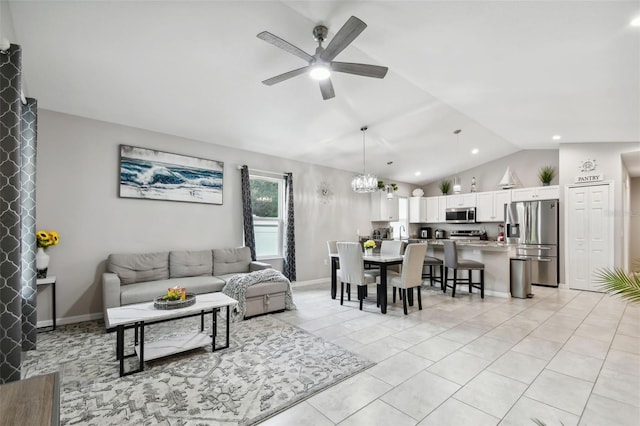 living room featuring lofted ceiling, ceiling fan with notable chandelier, and light tile patterned floors