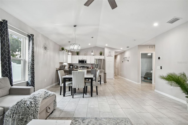 dining space featuring lofted ceiling, light tile patterned floors, and ceiling fan