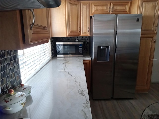 kitchen with hardwood / wood-style floors, backsplash, stainless steel appliances, and extractor fan