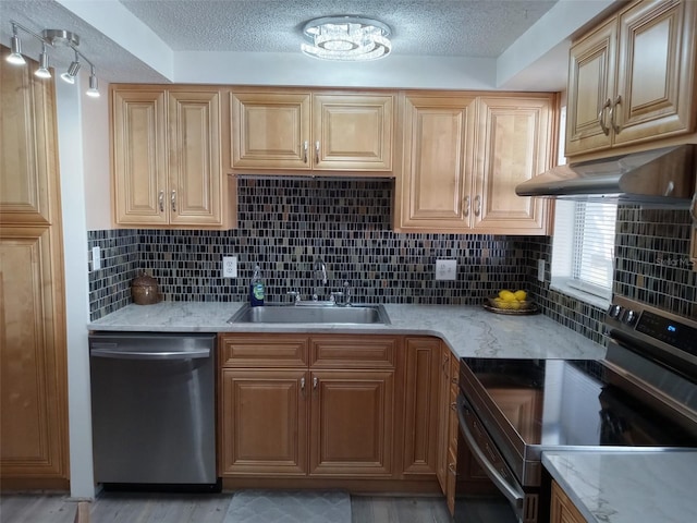 kitchen with decorative backsplash, a textured ceiling, stainless steel appliances, sink, and light hardwood / wood-style flooring