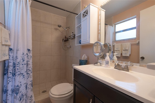 bathroom featuring tile patterned flooring, vanity, toilet, and curtained shower