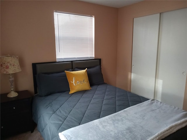 bedroom with dark carpet and a closet