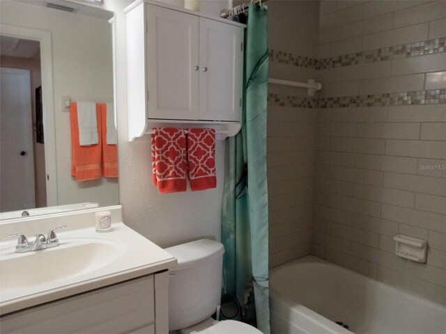 full bathroom with vanity, toilet, and shower / bath combo with shower curtain