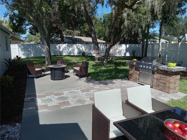 view of patio / terrace with an outdoor kitchen, a fire pit, and grilling area