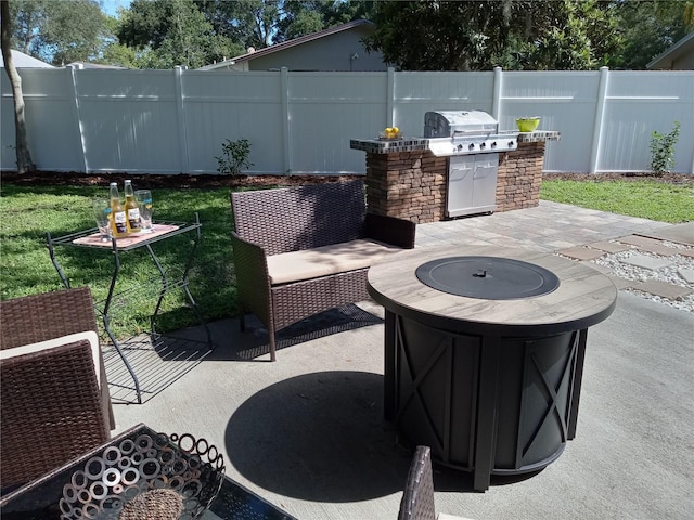 view of patio with exterior kitchen, an outdoor fire pit, and grilling area