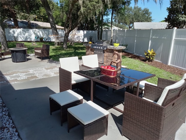 view of patio with area for grilling, exterior kitchen, and a fire pit