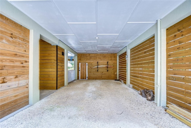 hall with carpet flooring and wood walls