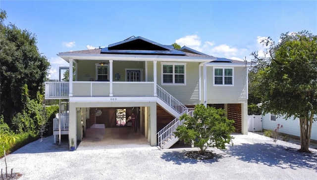 beach home featuring a carport, solar panels, and covered porch