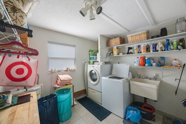 laundry area with washer and dryer, a textured ceiling, and sink