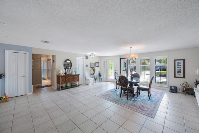 unfurnished dining area featuring a notable chandelier, a textured ceiling, and light tile patterned flooring