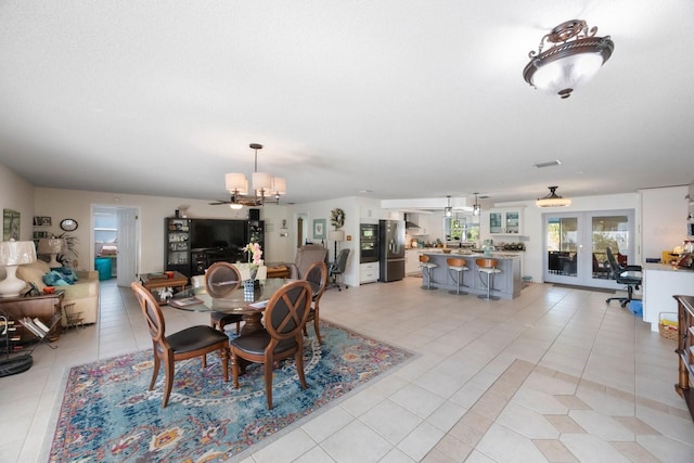 dining area featuring french doors, light tile patterned flooring, and a chandelier