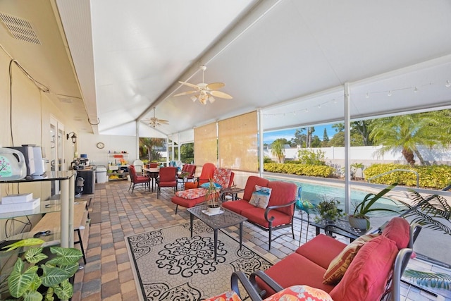 sunroom with ceiling fan, vaulted ceiling, and plenty of natural light